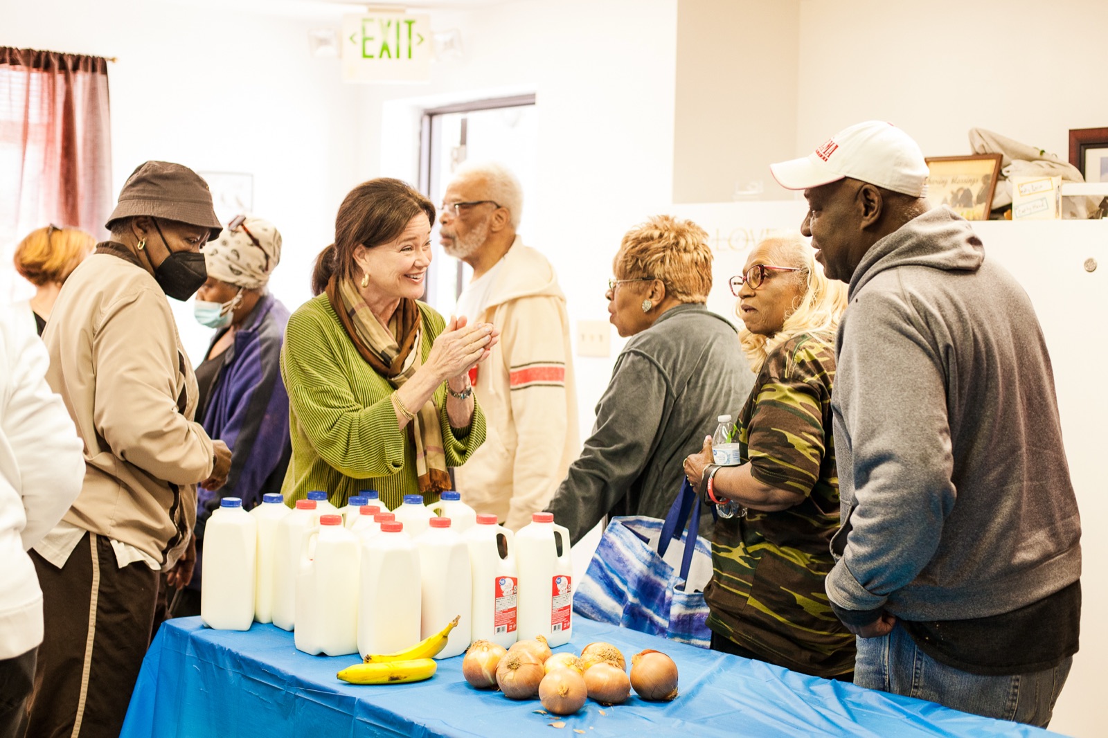 A volunteer and a neighbor in conversation across a table of groceries on a Saturday morning at Union Missionary Baptist Church