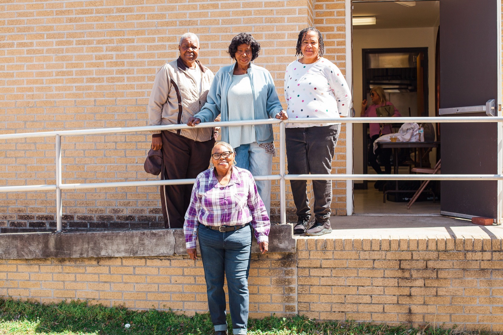 Neighbors stand together on the brick ramp outside Union Missionary Baptist Church